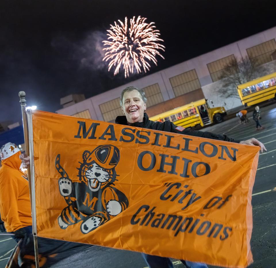 Massillon Tigers fan John Beal, class of 1978, holds a flag during the rally after Sunday's parade through downtown.