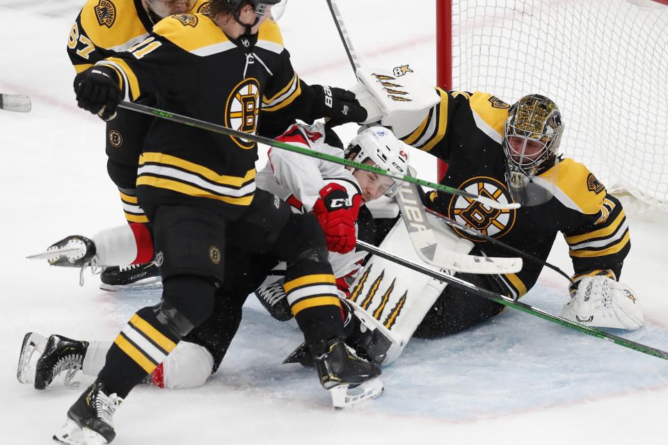 New Jersey Devils' Ty Smith (24) collides with Boston Bruins' Jaroslav Halak (41) during the second period of an NHL hockey game, Sunday, March 28, 2021, in Boston. (AP Photo/Michael Dwyer)