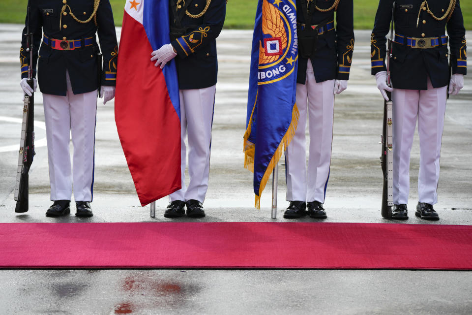 Honor guards arrange flags as they await the arrival of Philippine President Ferdinand Marcos Jr. on Tuesday, Jan. 3, 2023, at the Villamor Air Base in Manila, Philippines. Marcos Jr. will fly to China Tuesday. (AP Photo/Aaron Favila)