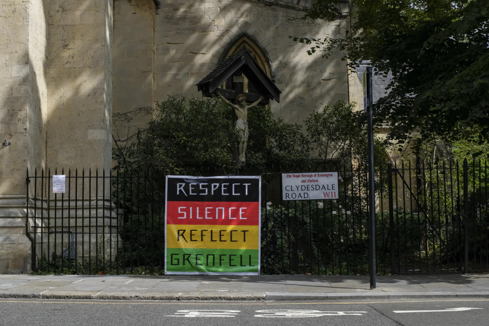 A Grenfell Tower sign is attached to a church, in the area of Notting Hill, in London, Monday, Aug. 31, 2020. Today would there have been the main parade of the iconic Notting Hill Carnival, cancelled due to the coronavirus outbreak. It will take place with live streaming performances. (AP Photo/Alberto Pezzali)