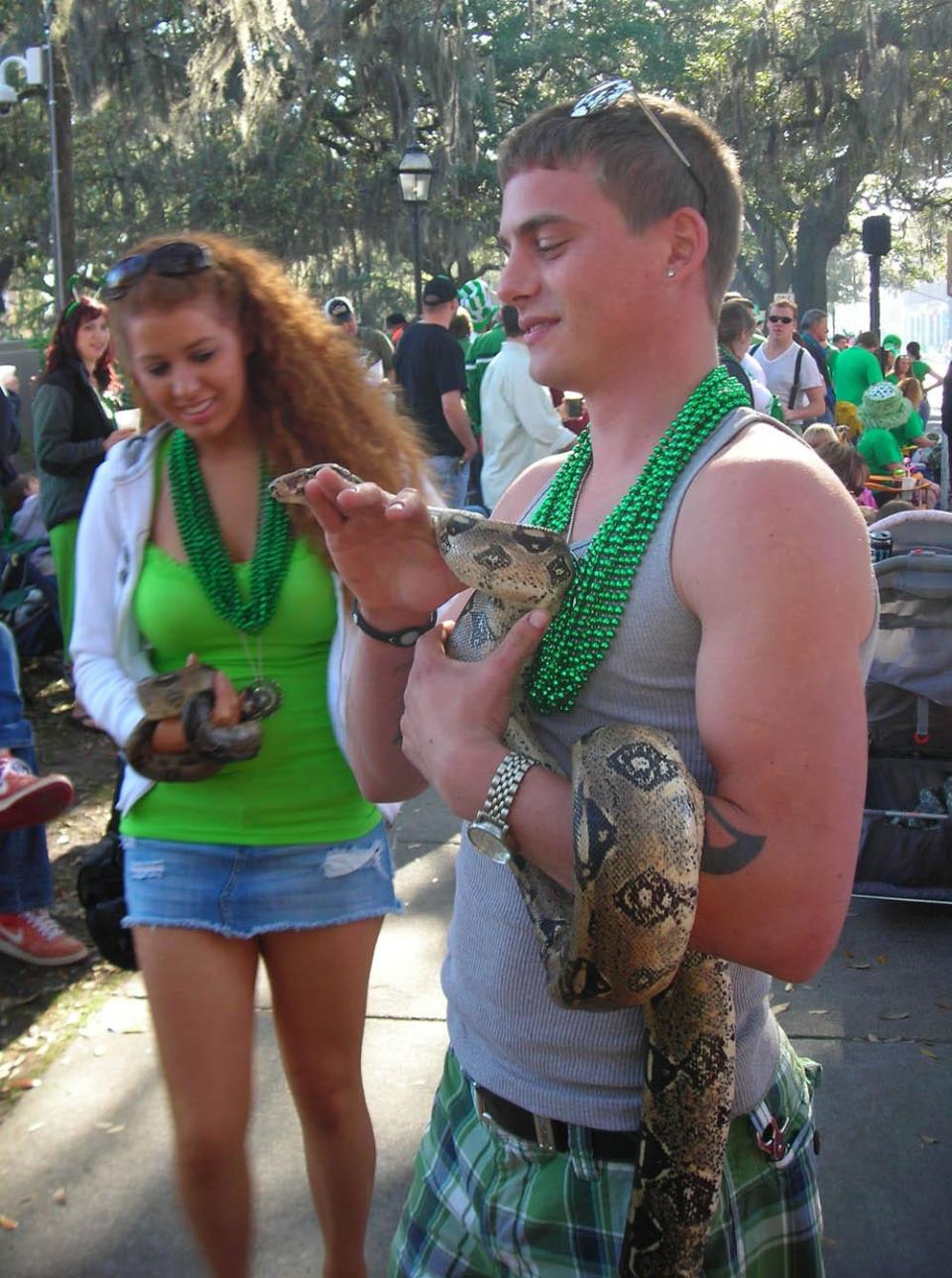 Chris Jones of Savannah took his Colombian red tail boa with him to the 2011 St. Patrick's Day Parade. Admiring the snake is Audrey McDaniel of Pooler.