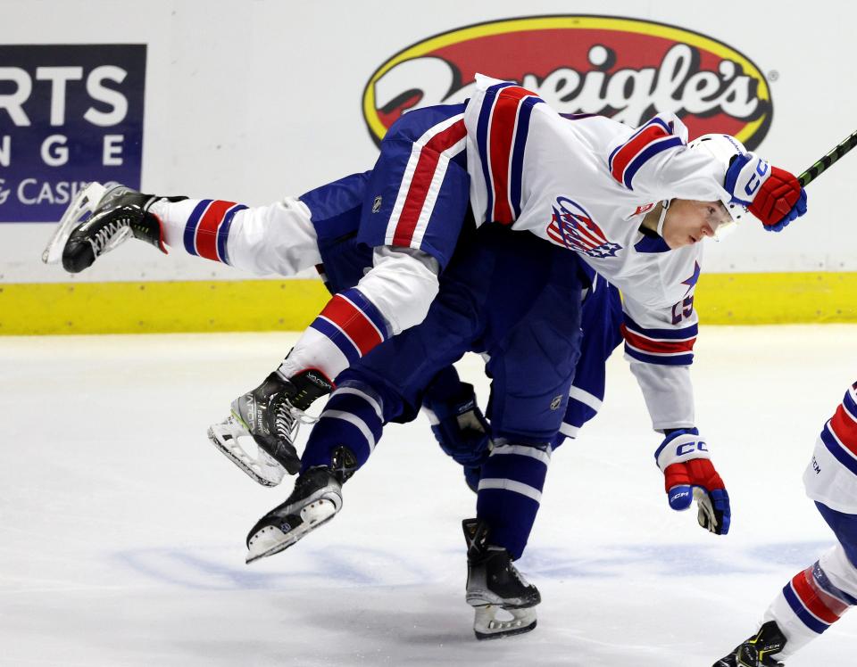 Amerk's Jiri Kulich tries to avoid a check by Toronto's Mac Hollowell near center ice.