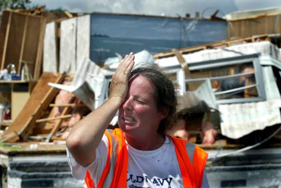 Michelle Smith, 40, wiped her eyes while standing in front of her father Richard Smith’s destroyed mobile home at Port Charlotte Village mobile home park in this Aug. 14, 2004, file phot. Her father stayed with her during Hurricane Charley in her home which had one bedroom blown out.