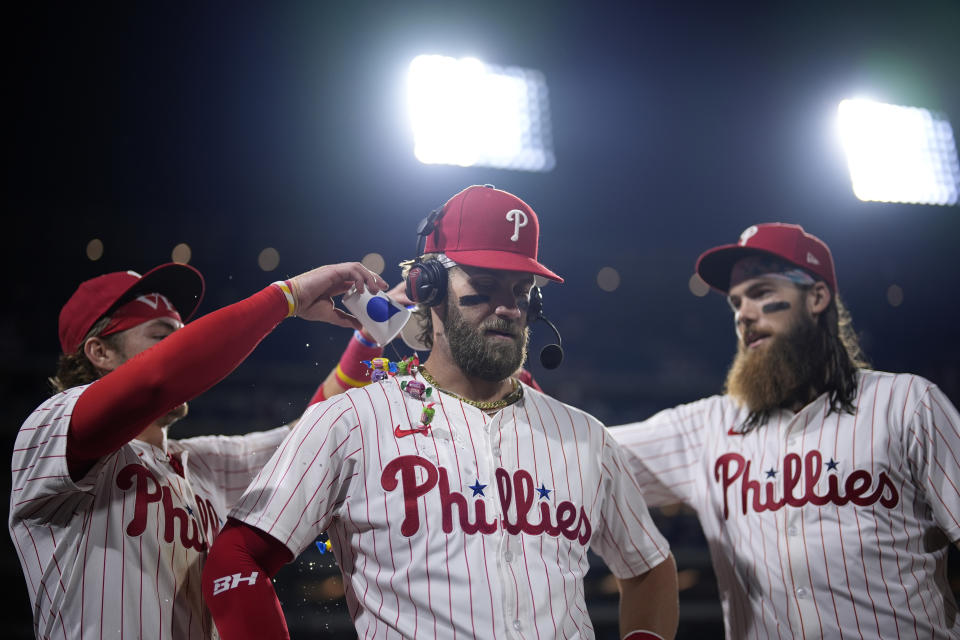 Philadelphia Phillies' Bryce Harper, center, celebrates with Bryson Stott, left, and Brandon Marsh after the Phillies won a baseball game against the Toronto Blue Jays, Tuesday, May 7, 2024, in Philadelphia. (AP Photo/Matt Slocum)