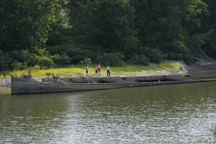 A barge dating back to World War II has re-emerged on the Po river in Gualtieri, Italy, Wednesday, June 15, 2022. Water is so low in large stretches of Italy's largest river that local residents are walking through the middle of the expanse of sand and shipwrecks are resurfacing, but authorities fear there'll be far greater consequences for farmers and local populations. (AP Photo/Luca Bruno)