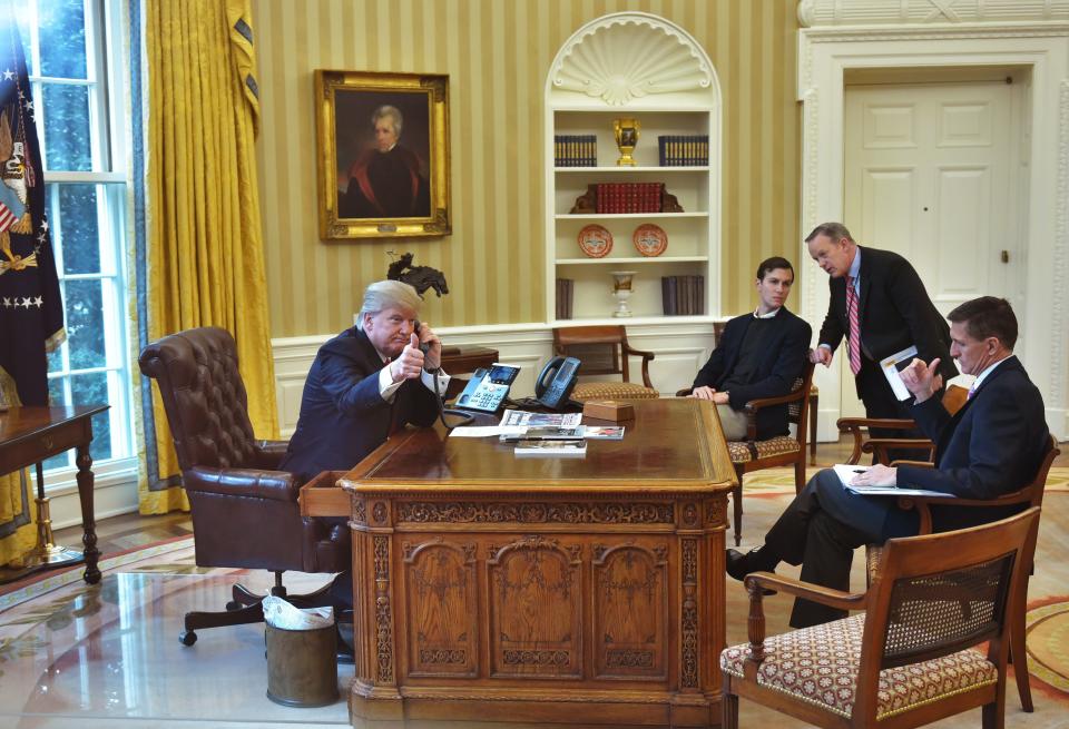 President Donald Trump seen through an Oval Office window gives a thumbs up as he speaks on the phone to King Salman of Saudi Arabia in the Oval Office of the White House on January 29, 2017 in Washington, DC.&nbsp;