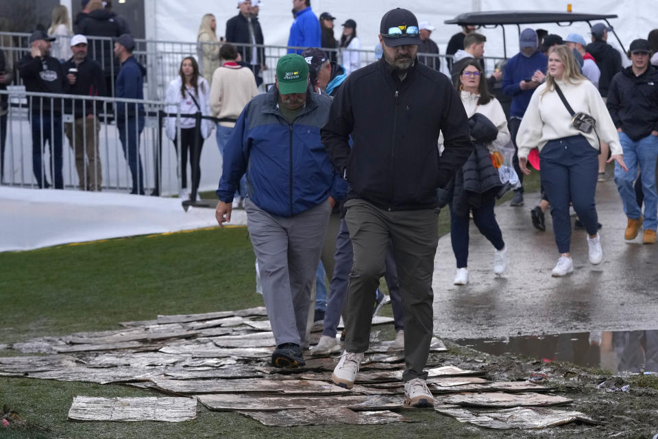 Fans walk the wet course during the continuation of second round of the Phoenix Open golf tournament Saturday, Feb. 10, 2024, in Scottsdale, Ariz. (AP Photo/Ross D. Franklin)