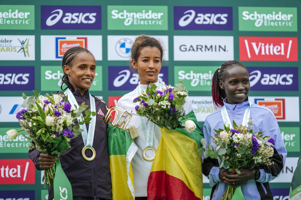 From left, Second-placed Enat Tirusew of Ethiopia, winner Mestawut Fikir of Ethiopia and third-placed Vivian Cheruiyot of Kenya pose on the podium after the women's race of the Paris marathon, in Paris, Sunday, April 7, 2024. (AP Photo/Lewis Joly)