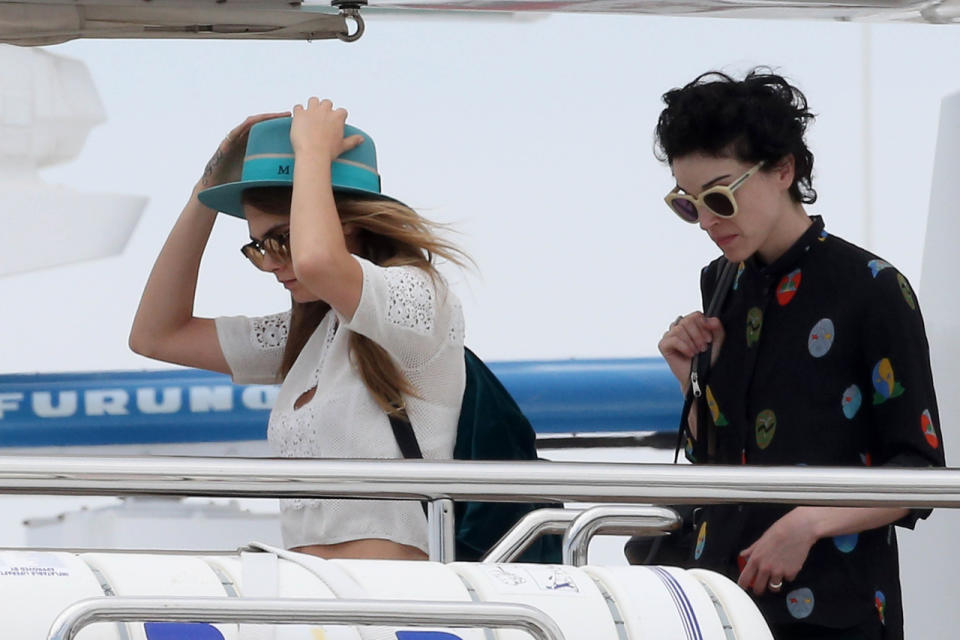 It looks like Delevingne, the model-turned-actress, is attempting to keep her hat from flying off deck. She didn’t stray from her casual-cool style, however, wearing ripped jeans and a crop-top. Her pal (or girlfriend?) wore a black shirt with playful polka dots and oversized yellow sunglasses. 