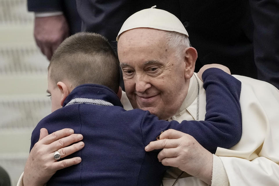 Pope Francis embraces a young boy during his weekly general audience in the Pope Paul VI hall at the Vatican, Wednesday, Jan. 31, 2024. (AP Photo/Andrew Medichini)