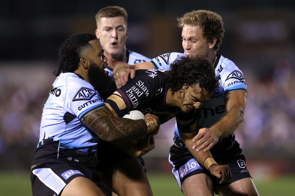 Pictured centre, Manly's Morgan Harper is tackled during the round seven NRL match against the Cronulla Sharks.