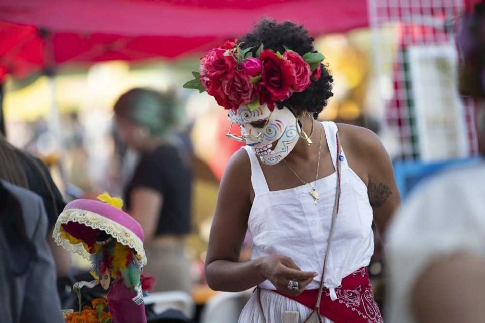 Merchant Taylor Cordova, or "The Flower Child Bruja" selling her products at the Dia De Los Muertos Festival at Steele Indian School Park on Oct. 30, 2022, in Phoenix.