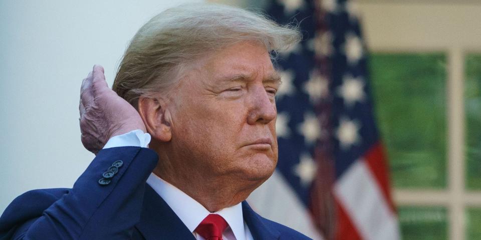 Donald Trump pats down his hair as he speaks during the Coronavirus Task Force daily briefing on COVID-19 in the Rose Garden of the White House in Washington, DC on March 30, 2020.