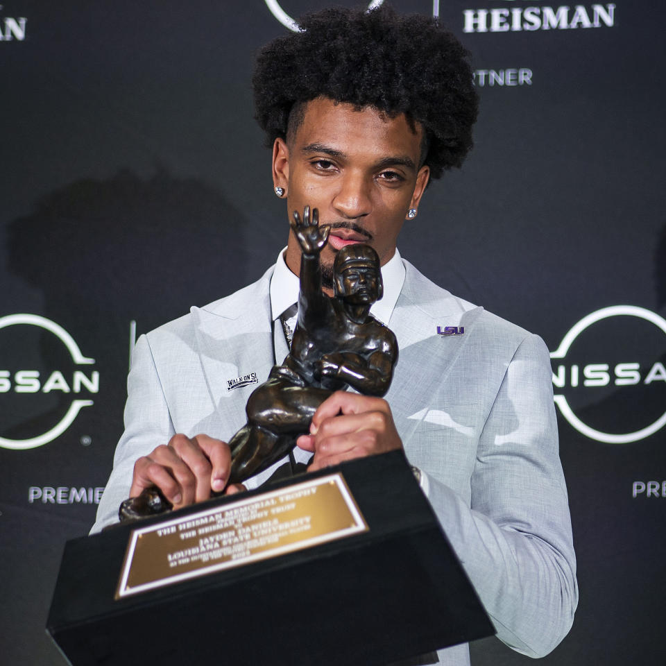 LSU quarterback Jayden Daniels kisses the Heisman Trophy during a news conference after winning the college football award, Saturday, Dec. 9, 2023, in New York. (AP Photo/Eduardo Munoz Alvarez)