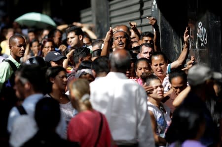 FILE PHOTO: Venezuelan citizens line up to buy food at a store in Caracas