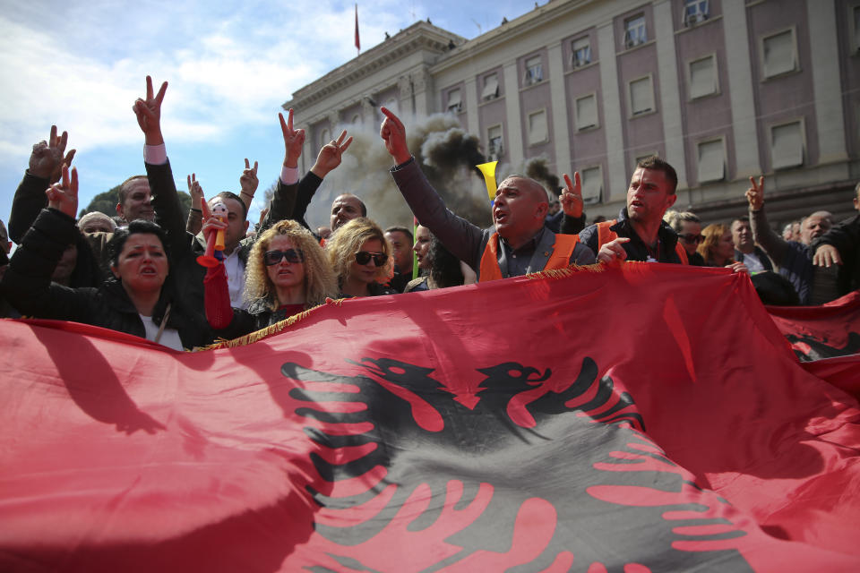 Protesters waving an Albanian flag shout slogans near the government building during a protest in Tirana, Albania on Saturday, March 16, 2019. Albanian opposition supporters clashed with police while trying to storm the parliament building Saturday in a protest against the government which they accuse of being corrupt and linked to organized crime.(AP Photo/Visar Kryeziu)