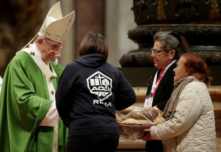 Pope Francis is offered bread as he leads a special mass to mark the new World Day of the Poor in Saint Peter's Basilica at the Vatican, November 19, 2017. REUTERS/Max Rossi