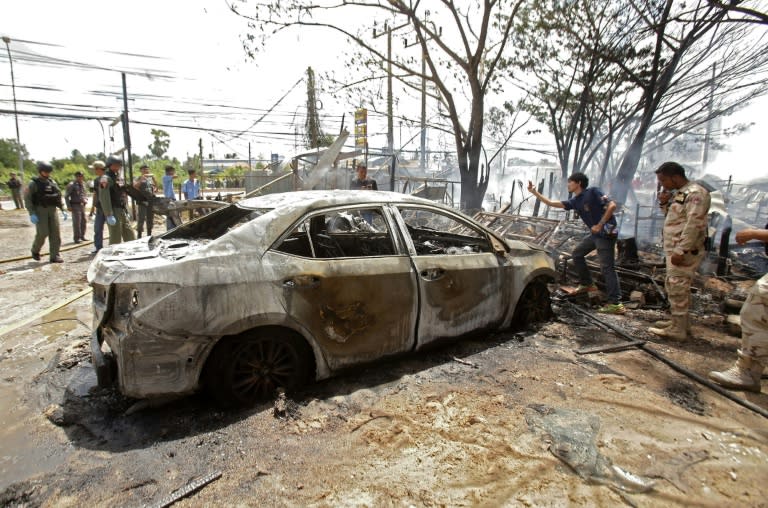 Bomb squad officers inspect a burnt out car after a blast in Thailand's restive southern province of Pattani on February 27, 2016