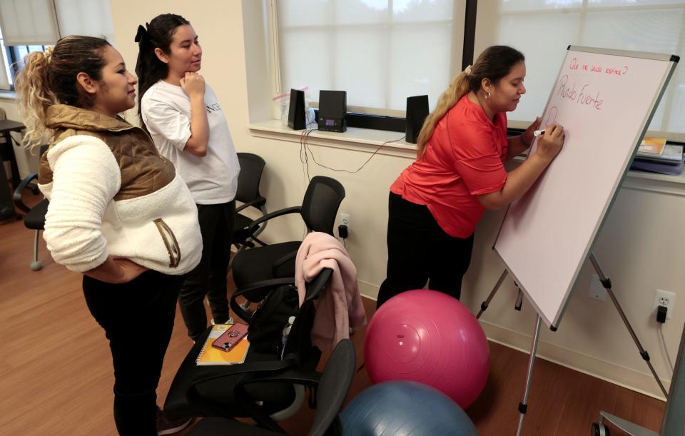 Edith Banos, 29, left, Keydell Fajrdo, 25, and Mercedes Cano, 32, write down things that can cause them stress in their pregnancy during a session at Covenant Community Care's Centering Pregnancy program in Detroit on Oct. 11, 2023. Centering Pregnancy offers private prenatal care and group learning on the importance of relaxation during pregnancy, and prenatal yoga exercise routines that can be done at home, among other things.