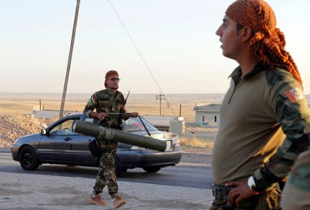 A Kurdish Peshmarga fighter carries a rocket in north of Kirkuk, Iraq October 19, 2017. REUTERS/Ako Rasheed