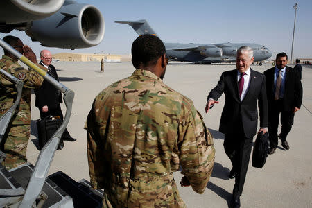 U.S. Defense Secretary James Mattis (R) greets an airman as he boards a U.S. Air Force C-17 for a day trip to a U.S. military base in Djibouti from Doha, Qatar April 23, 2017. REUTERS/Jonathan Ernst