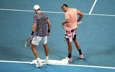 Nick Kyrgios of Australia walks around to the other side of the court to give Karen Khachanov of Russia a towel so he can wipe the floor during their Men's Singles third round match on day six of the 2020 Australian Open at Melbourne Park on January 25, 2020 in Melbourne, Australia