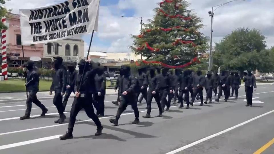 Dressed in all-black, the group was led by a single unmasked man and another member who held a megaphone. Photo: Twitter