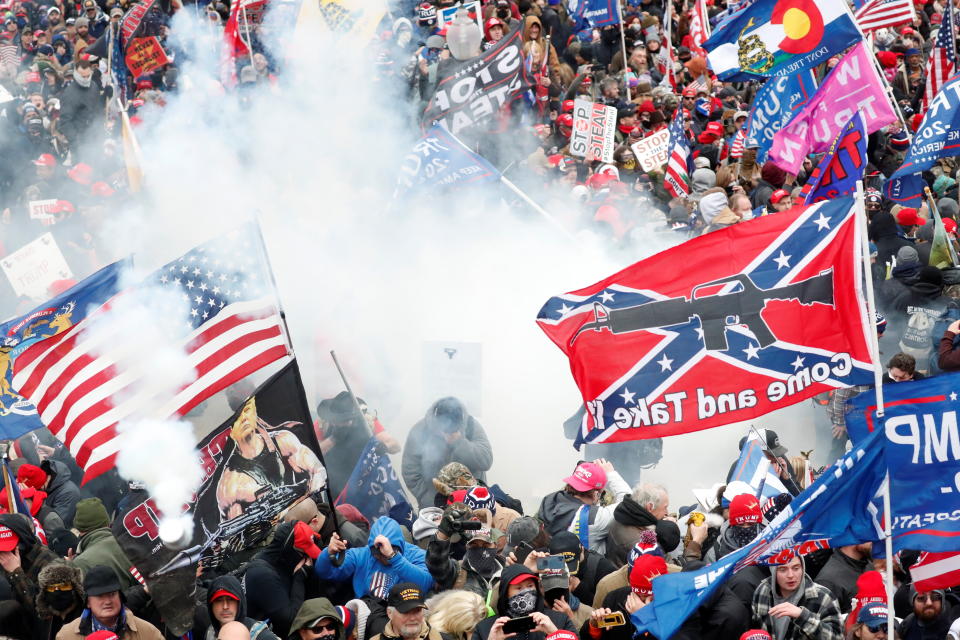 Tear gas is released into a crowd of protesters, with one wielding a Confederate battle flag that reads "Come and Take It," during clashes with Capitol Police at the U.S. Capitol on Jan. 6. (Photo: Shannon Stapleton / Reuters)