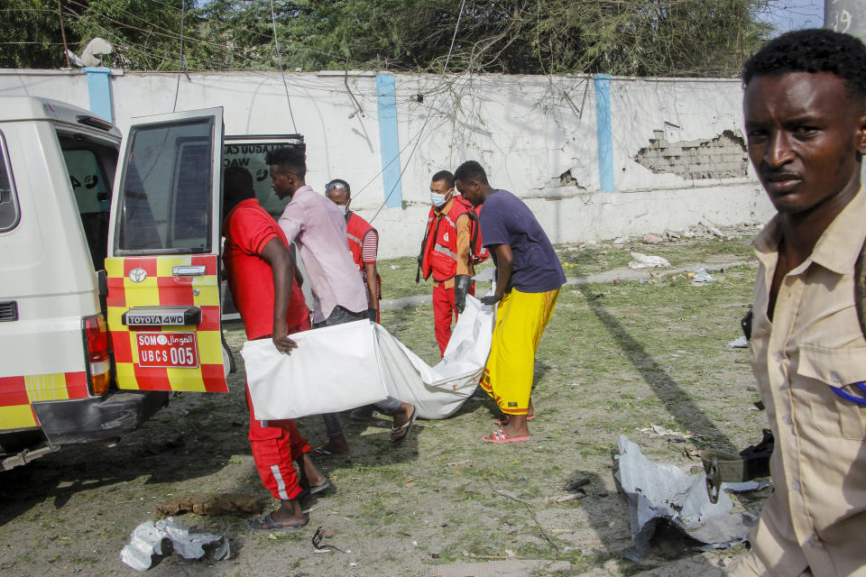 Rescue workers carry away the body of a civilian who was killed in a blast in Mogadishu, Somalia Thursday, Nov. 25, 2021. Witnesses say a large explosion has occurred in a busy part of Somalia's capital during the morning rush hour. (AP Photo/Farah Abdi Warsameh)