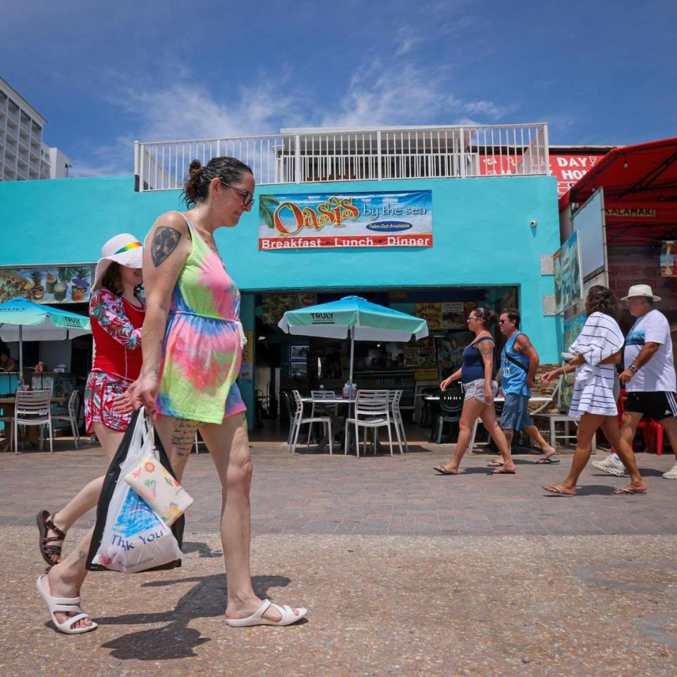 On Tuesday, May 30, 2023 police officers, tourists and locals mingle on the Hollywood Beach Broadwalk the day after a mass shooting left nine people injured. A witness recounts his efforts to help wounded people. -- Carl Juste/cjuste@miamiherald.com