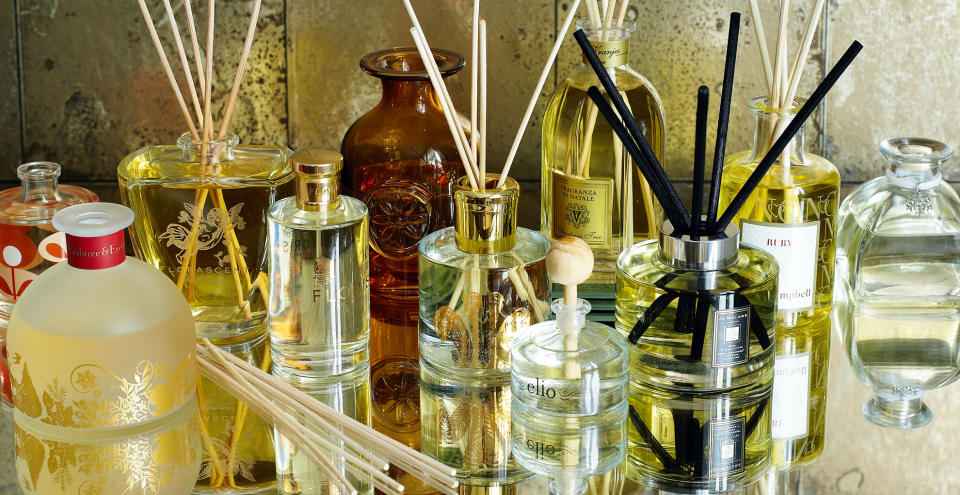 Mirrored sideboard filled with fragrance diffusers to show how to make a house smell good with scents