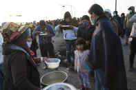 Farmworkers eat breakfast as they block the Pan-American South Highway on the fourth day of protests against the Agricultural Promotion Law, in Villacuri, Ica province, Peru, Thursday, Dec. 3, 2020. The workers are asking for the elimination of a law, demanding better wages and health benefits. (AP Photo/Rodrigo Abd)