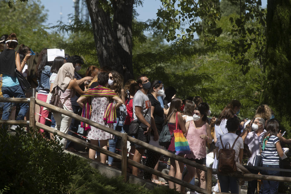 Profesores y personal auxiliar hacen fila para hacerse una prueba de COVID-19 en Madrid, España, el miércoles 2 de septiembre de 2020. Algunos padres españoles se resisten a enviar de vuelta a la escuela a sus hijos, en medio de un auge de los contagios de coronavirus. (AP Foto/Paul White)