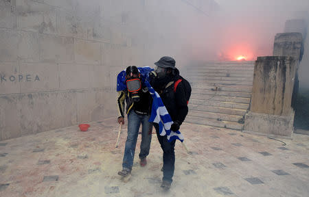 Protesters carry each other after clashes with police officers during a demonstration against the agreement reached by Greece and Macedonia to resolve a dispute over the former Yugoslav republic's name, in Athens, Greece, January 20, 2019. REUTERS/Alexandros Avramidis