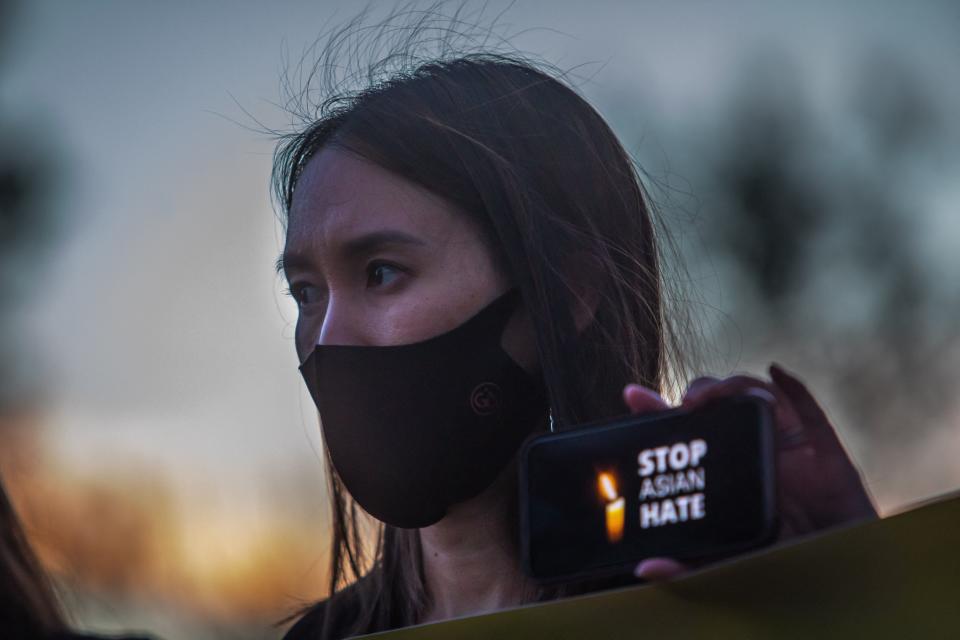 A woman holds her phone, featuring the message "Stop Asian Hate," during a candlelight vigil in Garden Grove, California, on March 17, 2021. (Photo: APU GOMES via Getty Images)