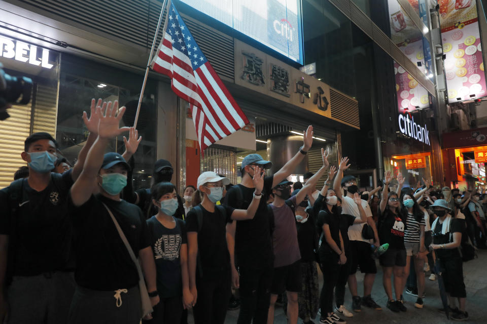 Masked protesters hold hands to form a human chain to protest against a ban on masks in Hong Kong on Saturday, Oct. 5, 2019. All subway and train services were suspended, lines formed at the cash machines of shuttered banks, and shops were closed as Hong Kong dusted itself off and then started marching again Saturday after another night of rampaging violence decried as "a very dark day" by the territory's embattled leader. (AP Photo/Kin Cheung)
