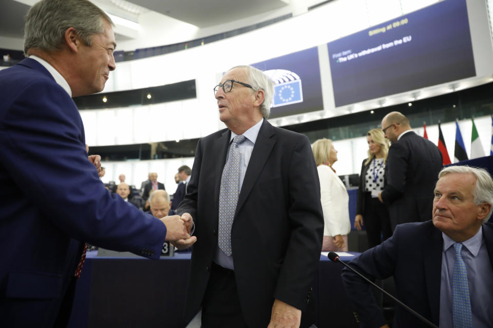 Brexit Party leader Nigel Farage, left, shakes hands to European Commission President Jean-Claude Juncker while European Union chief Brexit negotiator Michel Barnier, right, looks on Wednesday, Sept. 18, 2019 in Strasbourg. Members of the European Parliament discuss the current state of play of the UK's withdrawal from the EU. (AP Photo/Jean-Francois Badias)