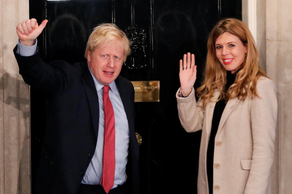 Britain's Prime Minister Boris Johnson and his girlfriend Carrie Symonds gesture as they arrive at 10 Downing Street on the morning after the general election in London, Britain, December 13, 2019. REUTERS/Thomas Mukoya