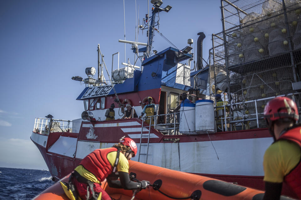 In this photo taken on Saturday, Nov. 24, 2018 photo, Members of Spanish NGO Proactiva Open Arms approach Nuestra Madre de Loreto, a Spanish fishing vessel that rescued twelve migrants and refugees two days ago about 78 miles north off Libyan shore. (AP Photo/Javier Fergo)