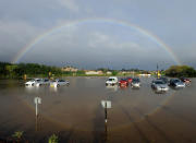 A rainbow reflects in surface water which covered a car park in Weymouth, Dorset.