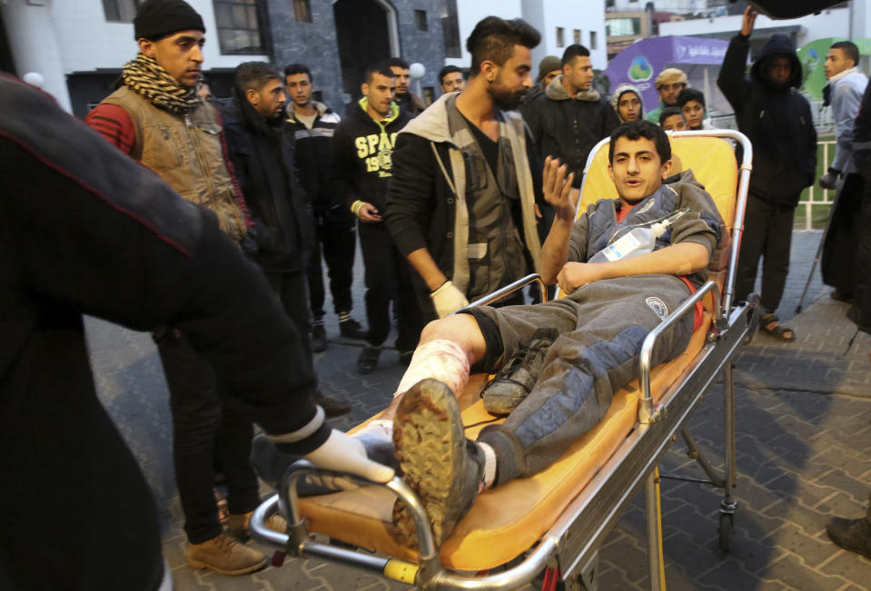 Palestinian medics wheel a wounded youth, who was shot by Israeli troops during a protest at the Gaza Strip's border with Israel, into the treatment room of Shifa hospital in Gaza City, Friday, Dec. 7, 2018. (AP Photo/Adel Hana)