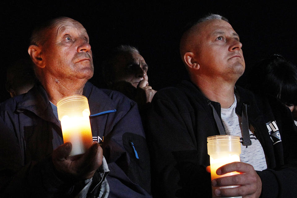 Spectators hold candles at the memorial service during a ceremony marking the 80th anniversary of the start of World War II, in Wielun, Poland, Sunday, Sept. 1, 2019. The ceremony in Wielun, attended by German President Frank-Walter Steinmeier and his Polish counterpart Andrzej Duda, started at 4.40 a.m., the exact hour that, according to survivors, the war's first bombs fell, killing civilians. (AP Photo/Czarek Sokolowski)