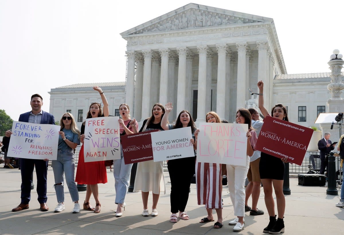 Demonstrators who supported Lorie Smith’s case celebrate the US Supreme Court ruling in Washington DC on 30 June (AP)
