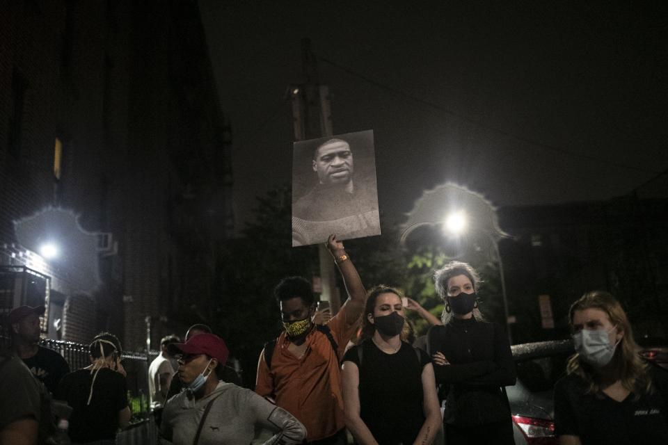 People watch as police arrest protesters for breaking a curfew during a solidarity rally calling for justice over the death of George Floyd, Friday, June 5, 2020, in the Brooklyn borough of New York. Floyd, an African American man, died on May 25 after a white Minneapolis police officer pressed a knee into his neck for several minutes even after he stopped moving and pleading for air. (AP Photo/Wong Maye-E)