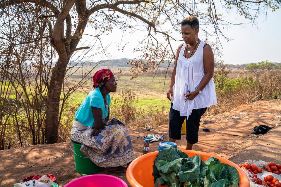 Deborah Barfield Berry, a reporter with USA TODAY, chats with a woman selling lettuce on the side of the road  in Angola. A team from the paper was in the country this summer working on a package of stories for its 1619 slavery project.