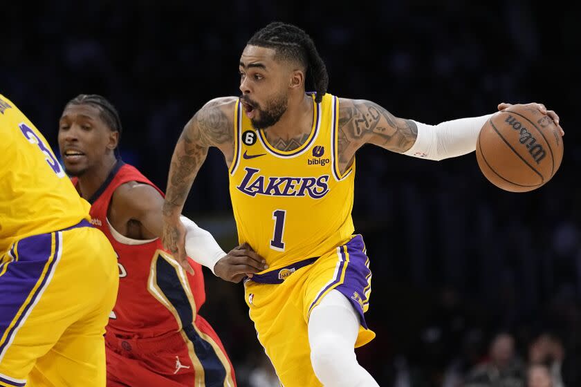 Los Angeles Lakers guard D'Angelo Russell, right, drives past New Orleans Pelicans guard Josh Richardson during the second half of an NBA basketball game Wednesday, Feb. 15, 2023, in Los Angeles. (AP Photo/Mark J. Terrill)