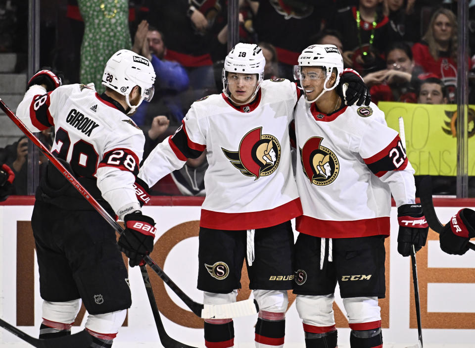 Ottawa Senators center Tim Stutzle (18) celebrates a goal against the Carolina Hurricanes with teammates Claude Giroux (28) and Mathieu Joseph (21) during the second period of an NHL hockey game in Ottawa, Ontario, on Sunday, March 17, 2024. (Justin Tang/The Canadian Press via AP)