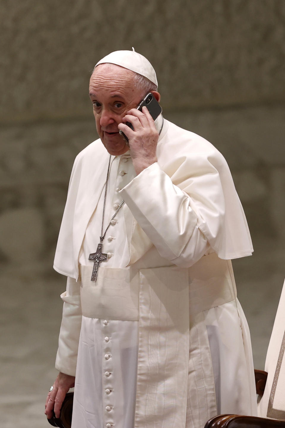 Pope Francis speaks on a cell phone, given to him by his aide Piergiorgio Zanetti, at the end of his weekly general audience in the Paul VI hall at the Vatican, Wednesday, Aug. 11, 2021. (AP Photo/Riccardo De Luca)