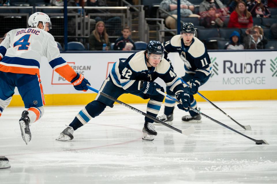 Oct 28, 2023; Columbus, Ohio, United States;
Columbus Blue Jackets center Alexandre Texier (42) reaches for the puck against New York Islanders defenseman Samuel Bolduc (4) during the third period of their game on Saturday, Oct. 28, 2023 at Nationwide Arena.