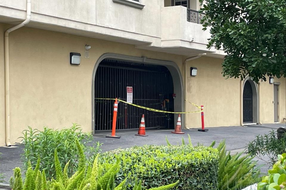 On Friday outside the complex, yellow caution tape was still in place around the gate that Johnson allegedly ploughed through in her Porsche SUV during her escape (Mike Bedigan/ The Independent)
